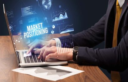 Businessman working on laptop with MARKET POSITIONING inscription, new business concept