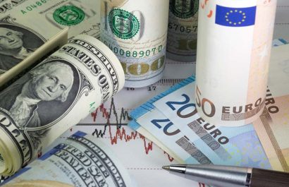 Rolled Us dollar bills and euro bills lying on the chart of dollar euro prices.Black and red lines on the diagram. Pen on the graph. Concept of currencies trading. Twenty, fifty euros .