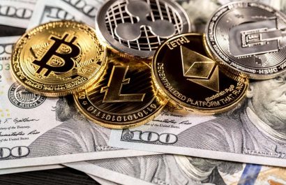 Silver and golden coins with bitcoin, ripple and ethereum symbol on wood background.