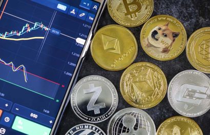 Mobile trading Stocks and Crypto currencies with shiny silver and gold physical digital currency symbols coins. Bitcoin, Ethereum, Litecoin, zcash, ripple, Doge