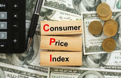 CPI, consumer price index symbol. Wooden blocks with words CPI, consumer price index on dollar bills with a calculator, coins.  Business and CPI, Business and consumer price index concept.