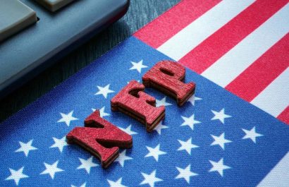 USA flag and wooden letters NFP Nonfarm Payrolls on it.