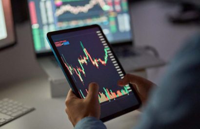Business man trader broker analyst investor holding tab in hands using digital tablet analyzing stock trade crypto market carts investing finances in stockmarket working in dark night office. Close up
