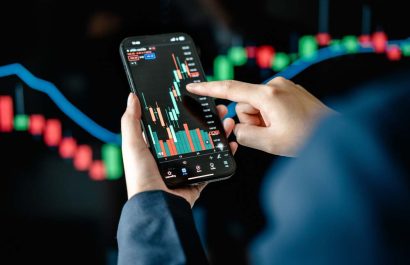 Investors analyze the data stock market index via smartphone screen to trade the stock chart for planning investments take profit, trade stock exchange market and cryptocurrency data, financial.